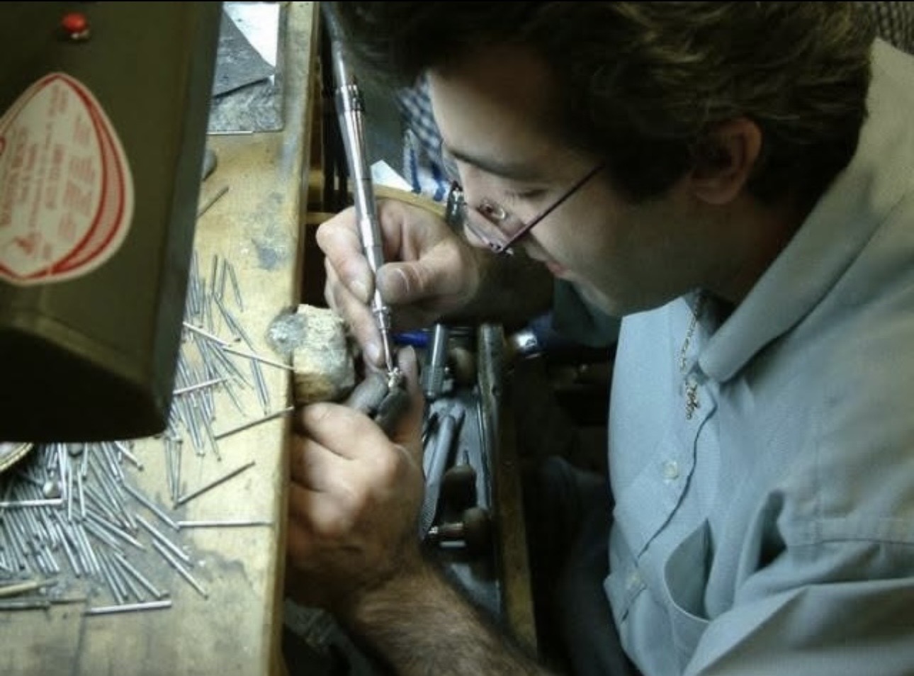 Master jeweler meticulously crafting a fine piece of jewelry at the workbench